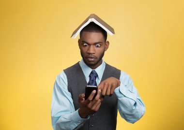 şok adam elinde telefon, kitap üzerinde kafa