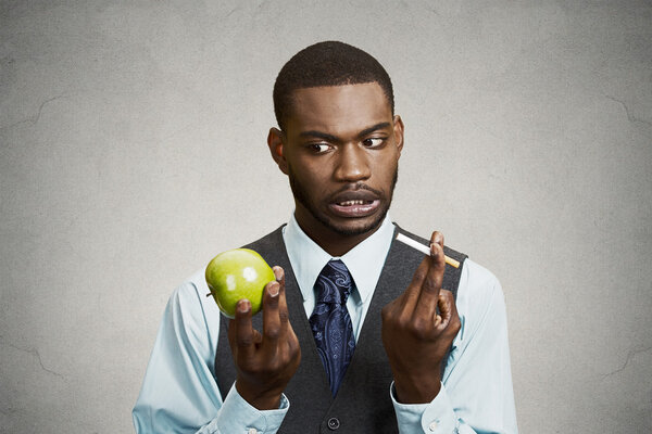 Запутавшийся человек жаждет сигареты, делает неправильный выбор в пользу здоровья
