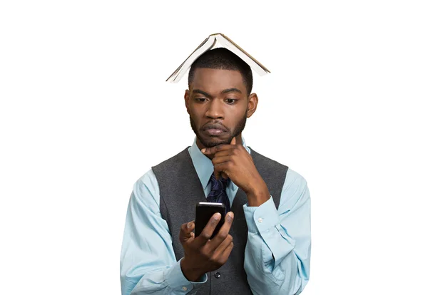 Man holding mobile, book over head — Stock Photo, Image