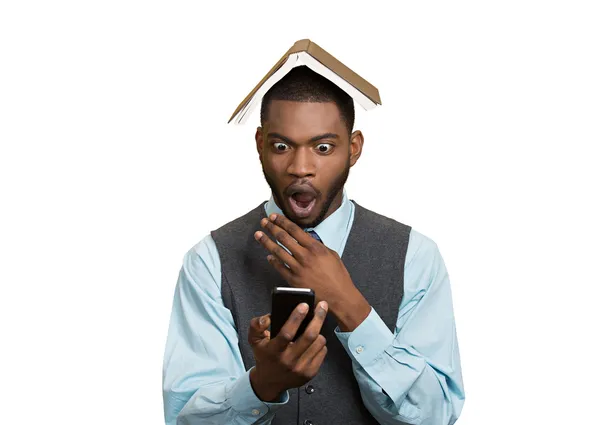 Man holding mobile, book over head — Stock Photo, Image