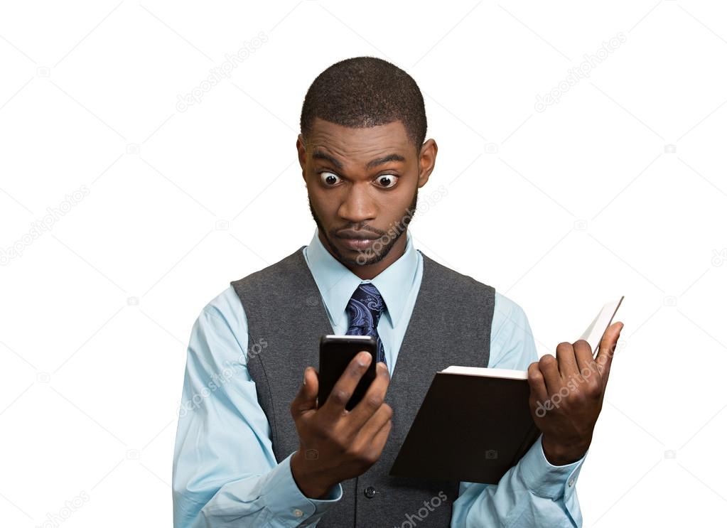 Shoked man with phone holding book