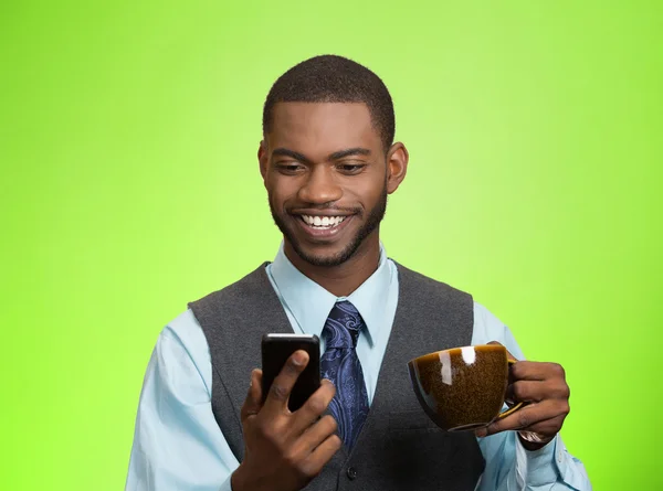 Lächelnder Geschäftsmann liest Nachrichten auf dem Handy und trinkt Tee — Stockfoto