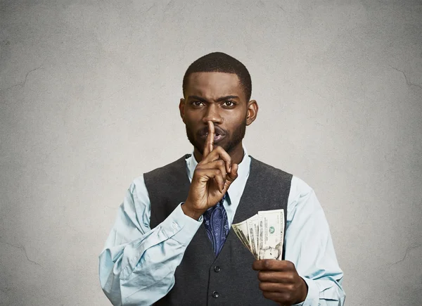 Hombre soborno con billetes de dólar en la mano y gesto tranquilo —  Fotos de Stock