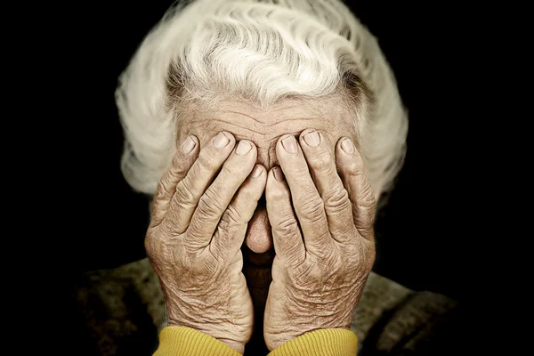 Closeup portrait depressed old woman covering her face with hand — Stock Photo, Image