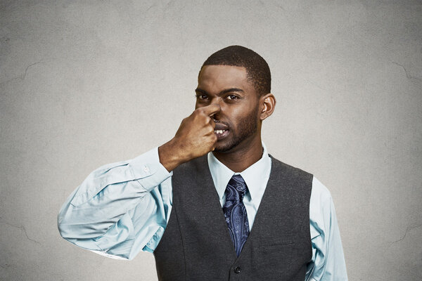 Man pinches his nose, very bad smell, odor