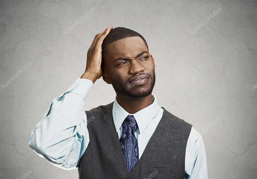 Confused man looks up on gray background Stock Photo by ©SIphotography