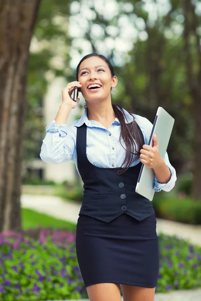 Mujer de negocios ocupada feliz caminando mientras habla en un teléfono inteligente — Foto de Stock