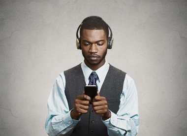 Phone addicted business man with headphones