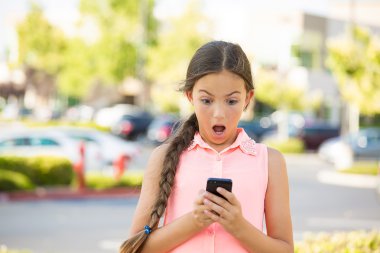 Shocked child texting on mobile, smart phone