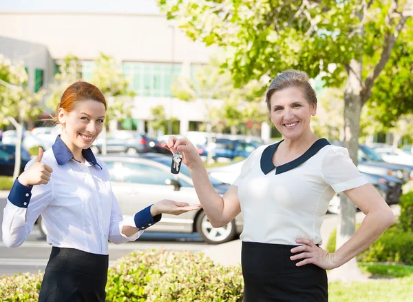 Wohnung, Autoverkauf. Verkäufer übergibt Schlüssel an Kunden — Stockfoto