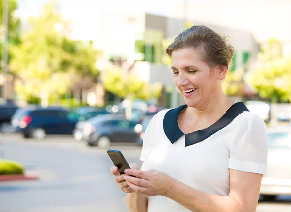 Glad kvinna textning på hennes smarta telefonen — Stockfoto