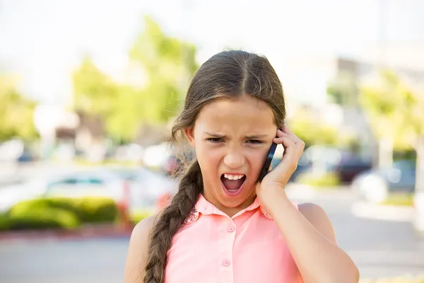 Злой ребенок кричит по мобильному телефону — стоковое фото