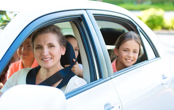 Família feliz sentada em um carro — Fotografia de Stock