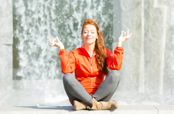 Городская женщина медитирует в городском парке — стоковое фото