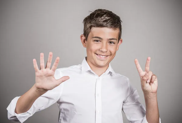 Šťastný teenager zobrazeno sedm prstů, číslo 7 gesto — Stock fotografie