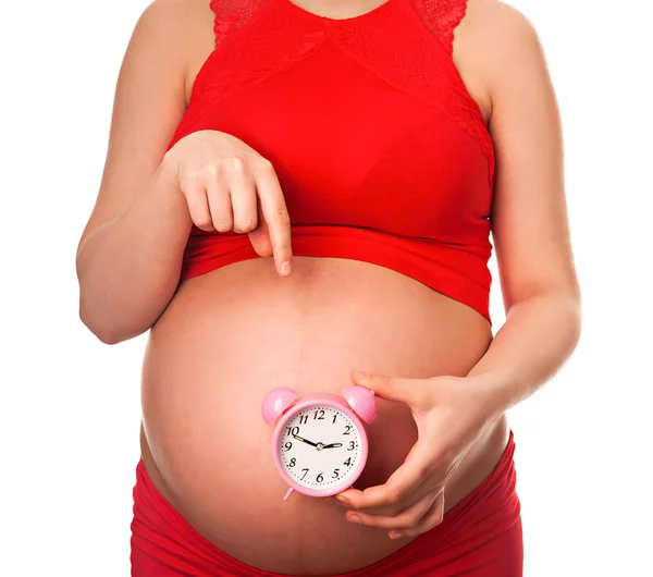 Mulher grávida segurando despertador esperando para entregar em breve — Fotografia de Stock