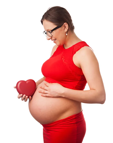 Glücklich schwangere Frau hält Herz neben ihrem dicken Bauch — Stockfoto