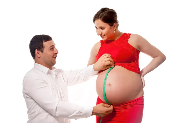 Far med måttband, kontrollera magen storlek pregnat hustru — Stockfoto