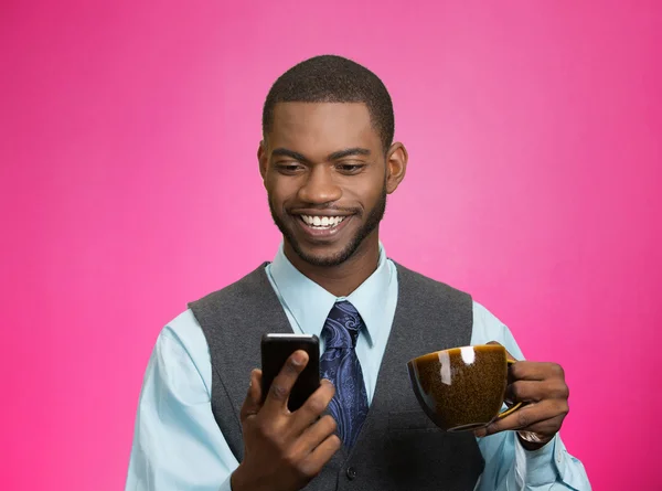 Empresário sorridente lendo notícias no celular e bebendo chá — Fotografia de Stock