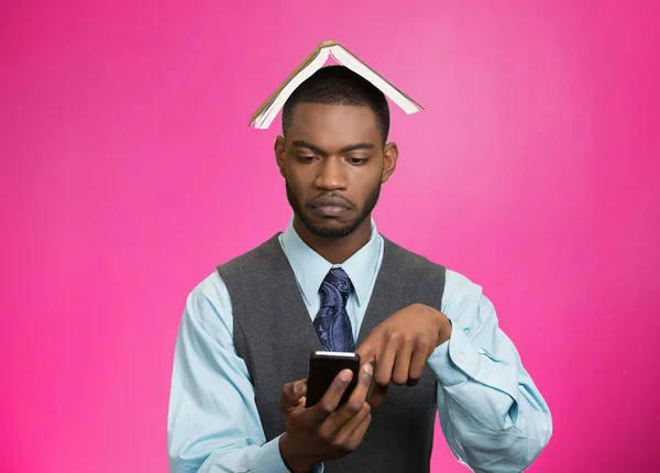 Man with book over head reading news on mobile — Stock Photo, Image