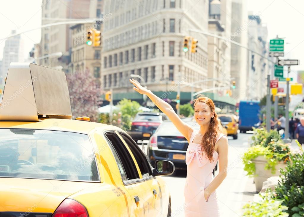 Happy woman hailing taxi cab in Manhattan  New York city