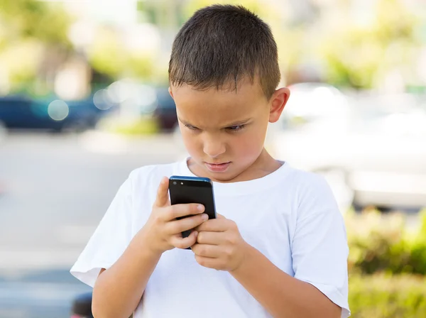 Nešťastný chlapec při pohledu na jeho chytrý telefon — Stock fotografie