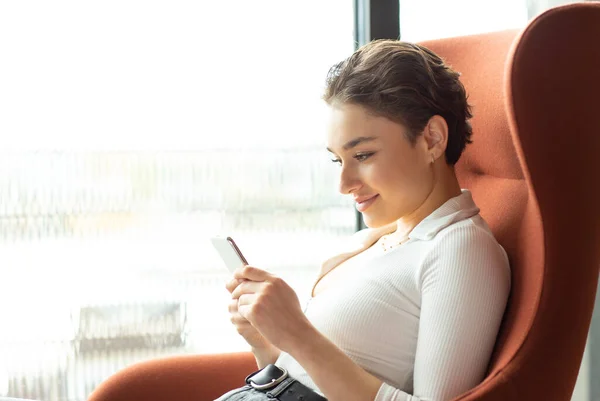 Hermosa Mujer Sentada Sillón Una Habitación Hotel Junto Ventana Usando —  Fotos de Stock