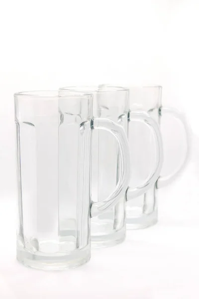 Three empty beer mugs with handles on a white background — Stock Photo, Image