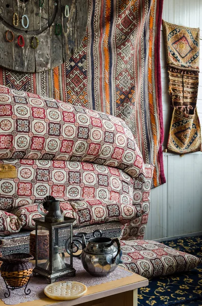 Duvarda, lambada, su ısıtıcısında geleneksel desenli dokuma halılar, dekorasyon ayrıntıları.