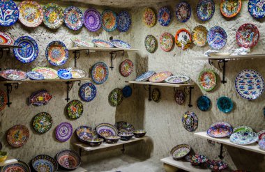 Uchisar, Türkiye - 11 Kasım 2017: Kapadokya bölgesindeki bir hediyelik eşya dükkanında elde boyanmış seramik tabaklar ve tabaklar sergileniyor
