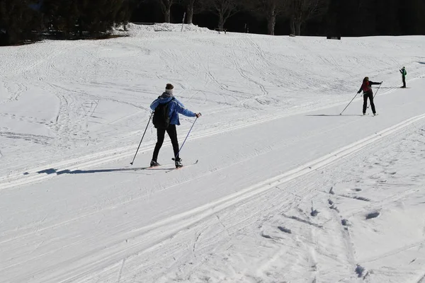 cross-country skiers go down the hill uncertainly