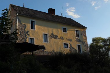 a house with a yellow facade in the setting sun