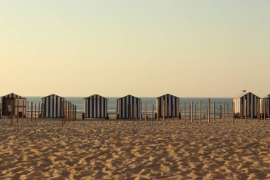 Gün batımında kabini değişen kumlu sahil.