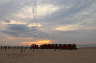 Gün batımında kabini değişen kumlu sahil.