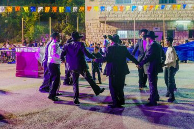 Güvenli, İsrail - 28 Eylül 2021: Simchat Torah geleneğinin bir parçası olan Musevi erkekler dans ediyor, kadınlar bariyerin arkasında, Safed (Tzfat), İsrail