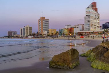 Tel Aviv, İsrail - 22 Kasım 2021: Mavi saat (günbatımından sonra), otel binaları ve ziyaretçilerle sahnenin görüntüsü. Tel-Aviv, İsrail