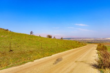 Arka planda toprak yol, manzara ve Hermon Dağı görünüyor. Golan Tepeleri, Kuzey İsrail