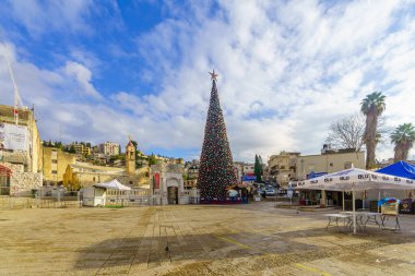 Nasıra, İsrail - 24 Aralık 2021: Nazareth, İsrail 'deki Yunan Ortodoks Annunciation Kilisesi ve bir Noel ağacı ile kilise meydanının manzarası