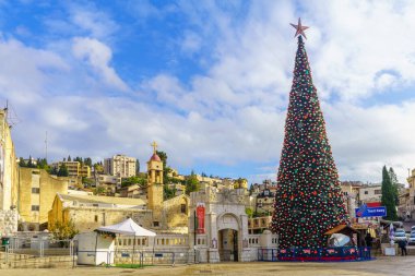Nasıra, İsrail - 24 Aralık 2021: Nazareth, İsrail 'deki Yunan Ortodoks Annunciation Kilisesi ve bir Noel ağacı ile kilise meydanının manzarası