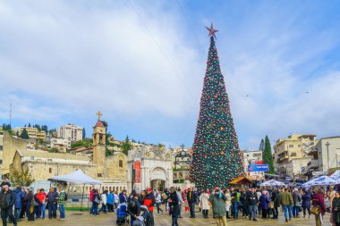 Nasıra, İsrail - 24 Aralık 2021: Nazareth, İsrail 'deki Yunan Ortodoks Annunciation Kilisesi, Noel ağacı, market tezgahları ve ziyaretçileri ile birlikte (Mary yakınlarında) kilise meydanı manzarası