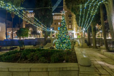 Kudüs, İsrail - 28 Aralık 2021: Yılbaşı ağacı ve Noel ışıklarıyla tarihi YMCA yerleşkesinin görüntüsü. Kudüs, İsrail