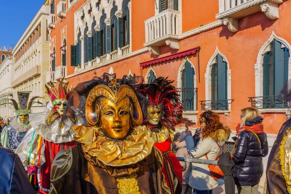 Venedik, İtalya - 28 Şubat 2022: Geleneksel kostümlü bir grup Venedik Maskeli Karnavalı 'nın bir parçası olan Riva degli Schiavoni rıhtımında, Veneto, İtalya