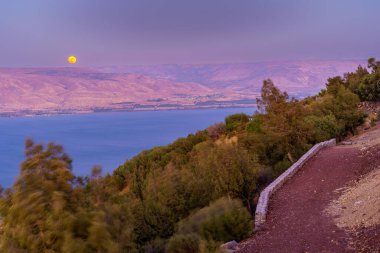 Galilee Denizi 'nin güneyinde güneş batışı manzarası, süper bir ay ile. Kuzey İsrail