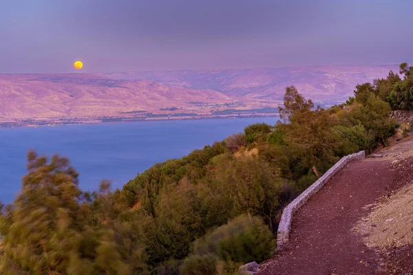 Galilee Denizi 'nin güneyinde güneş batışı manzarası, süper bir ay ile. Kuzey İsrail