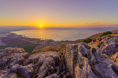Arbel, Israel - July 16, 2022: Sunrise view of the Sea of Galilee, from Mount Arbel (west side), with visitors. Northern Israel