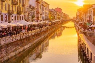 Milan, İtalya - 02 Mart 2022: Naviglio Grande kanalının Navigli, Milan, Lombardy, Kuzey İtalya 'da yerel halk ve ziyaretçilerle gün batımı manzarası