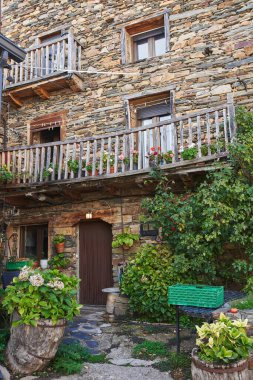 Valverde de los Arroyos, İspanya - 3 Ekim 2021: Guadalajara 'nın (İspanya) kuzey dağlarındaki kayrak çatılı, taş duvarlı ve bitki örtülü tipik bir ev.