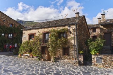 Valverde de los Arroyos, İspanya - 3 Ekim 2021: Guadalajara 'nın (İspanya) kuzey dağlarındaki kayrak çatılı, taş duvarlı ve bitki örtülü tipik bir ev.