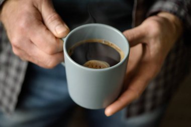 Bir adamın elinde bir fincan kahve.