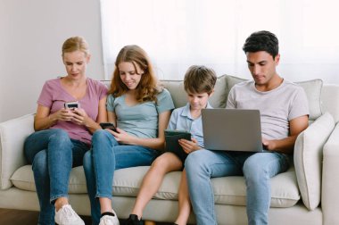 Kafkas ailesinin portresi ve farklı elektronik cihazlar kullanmak, online zaman geçirmek, oyunlar oynamak, evdeki oturma odasında kanepede otururken sosyal ağları kontrol etmek. Gadgets bağımlılığı.